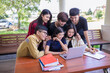 Group of Asian students are using laptops to use social media and search for information on the network