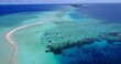 Aerial view of narrow sandbank in shallow turquoise ocean water in Asia
