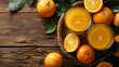 Freshly squeezed orange juice in glasses, surrounded by whole and halved oranges on a wooden table with green leaves.