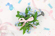 Bouquet of blue flowers and pink bow, pink and blue decorations, florist's desk top view.