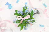 Fototapeta Kwiaty - Bouquet of blue flowers and pink bow, pink and blue decorations, florist's desk top view.