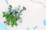 Fototapeta Kwiaty - Blue flowers, blue decorations and blank space to fill with content. Top view. 