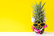 Summer in the party.  Hipster Pineapple Fashion in sunglass and listen music bright beautiful color in holiday, Creative art fruit  yellow background.  Summer Vacation Concept, copy space for text