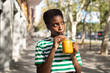 Happy African woman, drinking orange fruit juice with a straw