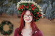 Beautiful red-haired girl in a wreath made of viburnum berries, ears of wheat, flowers and leaves