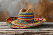 Traditional sombrero with intricate embroidery and festive colors rests on a rustic wooden table an emblem of Cinco De Mayo isolated on a white background, illustration