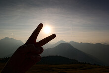 Catching The Sun With Fingers And Blurred Karwendel Mountainsin The Background, Alps, Tyrol, Austria, Europe