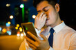 © sorapop - Tired businessman in suit rubbing eyes after using smartphone at night. Frustration due to eye strain serious about care concerns for eyesight street scene.