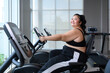 Asian overweight women exercising on the exercise bike in indoor fitness club. Healthy and Fitness concept. Weight loss workout, healthy lifestyle concept