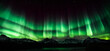 Aurora australis or Aurora borealis or Green northern lights sky above mountains. Night sky with polar lights. Night winter landscape with southern lights aurora against Real Natural black background.