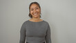 © Krakenimages.com - A smiling young adult hispanic woman poses in casual clothing against an isolated white wall background.