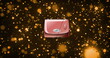 Image of pink handbag over glowing orange light spots moving on dark background