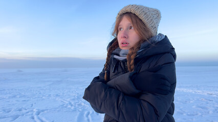 young woman is frozen, shaking outside, concept cold in winter