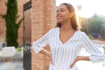 Wall Mural - Young african american woman smiling confident looking to the side at street