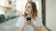 © Krakenimages.com - Young caucasian woman smiling confident using smartphone at street