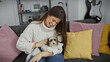 © Krakenimages.com - Smiling woman cuddles with biewer terrier in a cozy living room
