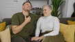 © Krakenimages.com - Laughing mature woman and young man sitting together on a sofa in a cozy living room