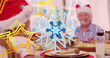 This image features a digital image of stars falling over a happy caucasian family wearing santa hat