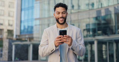 Canvas Print - Happy, city and man with smartphone, business and typing email with positive news and online reading. Person, outdoor and entrepreneur with cellphone, New York and PR consultant with social media