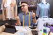Hispanic man with beard dressmaker designer working at atelier showing middle finger doing fuck you bad expression, provocation and rude attitude. screaming excited