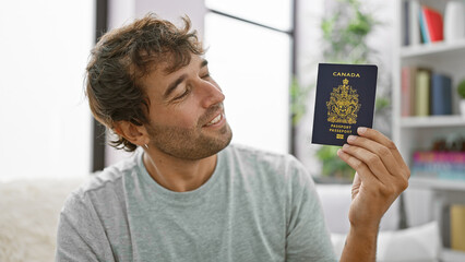 Poster - Happy young man, smiling and sitting at home on sofa, holding his canadian passport, ready for vacation!