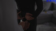 © Krakenimages.com - Silhouetted handcuffing scene indoors depicting a female officer detaining a man, suggesting a criminal arrest scenario.