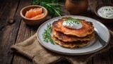 Fototapeta Kwiaty - Homemade potato pancakes. Rösti with smoked salmon and sour cream on a rustic wooden background. Traditional Swiss cuisine.
