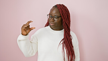 Poster - An adult black woman with braids and glasses gestures small size against a pink background