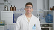 © Krakenimages.com - Radiant portrait of a young, handsome hispanic scientist confidently flashing a winning smile while enjoying his work at the lab, carefully wearing security glasses!