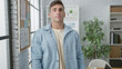 © Krakenimages.com - Portrait of a determined young hispanic man, a business worker, standing with a serious face in the office, the background of his daily work and success.