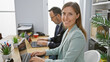 © Krakenimages.com - Two smiling business workers sitting together at office desk, confidently working on laptop in their professional attire