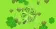Image of st patrick's day shamrock and green hearts on green background
