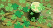 Image of st patrick's day shamrock and glass of beer on wooden background