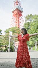 Poster - Beautiful hispanic woman in glasses with open arms, joyfully embracing the experience of tokyo's famous street