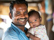 © VISUAL BACKGROUND - A man holding a baby smiles at the camera.