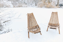 Two Garden Chairs With White Lambskin Outside On A Wooden Deck By The Lake. After Ski Outside In The Snow. Sitting Outside In Winter