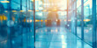 Blurred view of a modern office building interior with glass walls reflecting a cool blue tone and exuding a sleek corporate atmosphere
