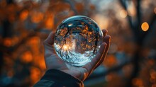 Hand Holding A Crystal Ball With An Autumn Scene - A Hand Gracefully Holds A Crystal Ball Reflecting A Beautiful Autumn Scene, Showcasing The Serene And Magical Aspect Of The Season