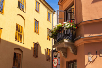 Wall Mural - Summer cityscape - view of old houses with flowers on the balconies on narrow streets in the Old Town of Warsaw, Poland