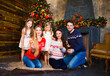 © Dasha Petrenko - Young family near fireplace celebrating Christmas