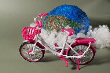 Hand made globe , clouds and pink bicycle. Bicycle day concept
