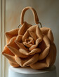 A mini handbag shaped like an oversized rose, made of crochet fabric with visible stitching and texture