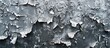 Close-up of a freezing grey wall covered in ice, with peeling paint visible underneath.