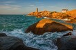 Lighthouse of Ploumanach at the golden hour in Perros-Guirec, Côtes d'Armor, Brittany, France. Sea tide, waves, lighthouse in the background.