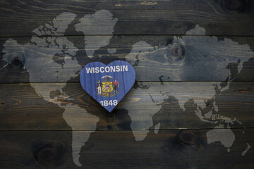 Wall Mural - wooden heart with national flag of wisconsin state near world map on the wooden background.