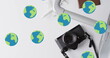 Image of globes over suitcase, passport, camera and plane model on white background
