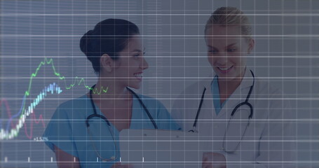 Canvas Print - Image of financial data processing over two caucasian female doctors