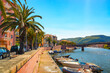 Picturesque view of Bosa town along Temo River in Sardinia, Italy, with boats, colorful buildings and palm trees