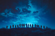 © Anek - A group of people are standing on a hill at night, looking up at the sky