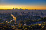 Fototapeta Zwierzęta - Hollywood downtown at sunrise with Los Angeles skyline in the background and traffic on US-101 highway in the foreground.